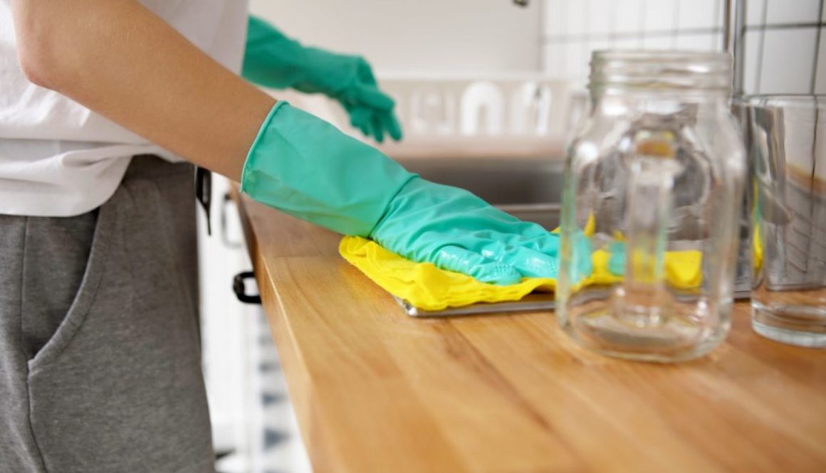 midsection-of-woman-cleaning-kitchen-counter-at-royalty-free-image-1585171591